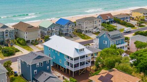 Zona residencial costera con casas que tienen balcones y una playa al fondo.