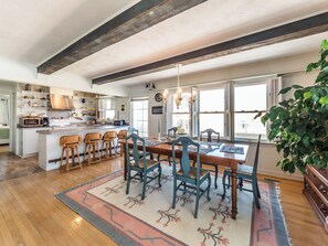 Una cocina amplia con una isla central, sillas de madera y una mesa de comedor para seis personas.