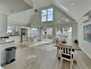 A spacious kitchen with a dining area, large windows, and a ceiling fan. - Sany Lu by Topsail Realty (Holly Ridge)