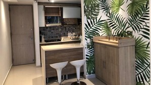 Une cuisine moderne dotée d’un îlot central, de meubles en bois et d’un revêtement mural décoratif à motifs géométriques.