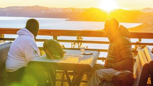 Two people sitting at a table with a view of a lake and mountains during sunset. - Charming 3-bedroom Ski Cabin on Golf Course in lovely Incline Village (Incline Village)