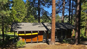 A rustic cabin with a wooden exterior, surrounded by tall pine trees. - Charming 3-bedroom Ski Cabin on Golf Course in lovely Incline Village (Incline Village)