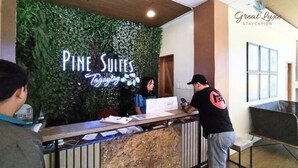 A reception desk with a sign reading "Pine Suites Today."