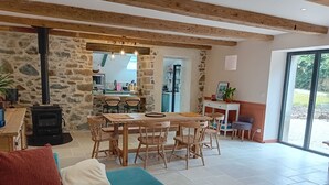 Un salón espacioso con pared de piedra, muebles de madera y un ventanal grande.