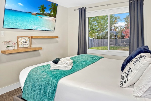 Bright Bedroom with Large Window and Smart TV