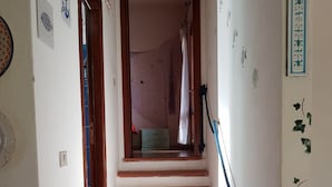 A staircase with red tiles leading to a room with a bed and a window. - Villa Stella Oasis of Peace in the Natural Park of Costa Paradiso Sardinia (Costa Paradiso)