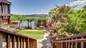 Terraza de madera con vistas a un lago y montañas.