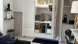 A modern, compact living space with a kitchenette, a dining area, and a sofa. - Ty paradis (Saint-François)
