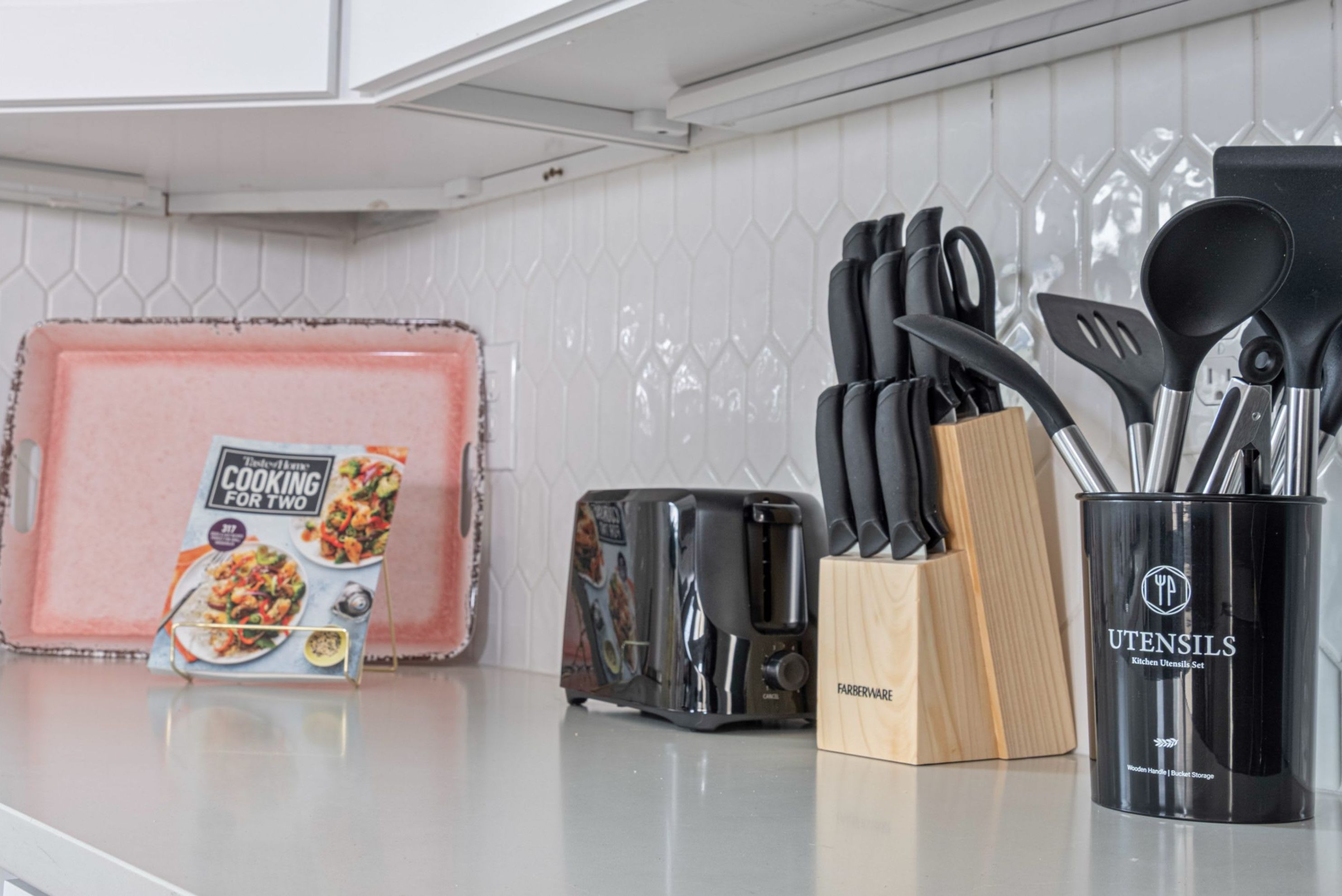 A kitchen counter with a toaster, a knife block, and a utensil holder.
