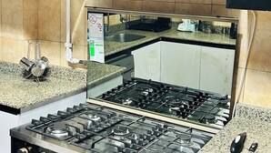 A kitchen with a cooktop, oven, and a stainless steel range hood.