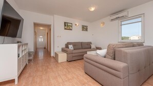 A modern living room with a flat-screen TV, a sofa set, and a dining area. - Stunning apartment in Ugrinic with WiFi (Ugrinic)