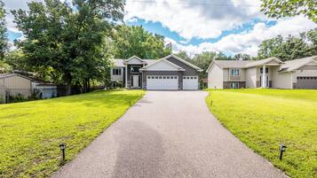 A residential area with a paved driveway leading to a house with a garage.