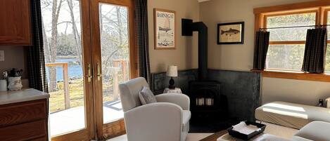 Una sala de estar acogedora con chimenea, un sofá, una mesa de centro y vistas al exterior.