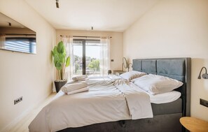 A bedroom with a large bed, a potted plant, a window with curtains, and a view of the outdoors. - Nice Home In Tar With Private Swimming Pool (Tar)