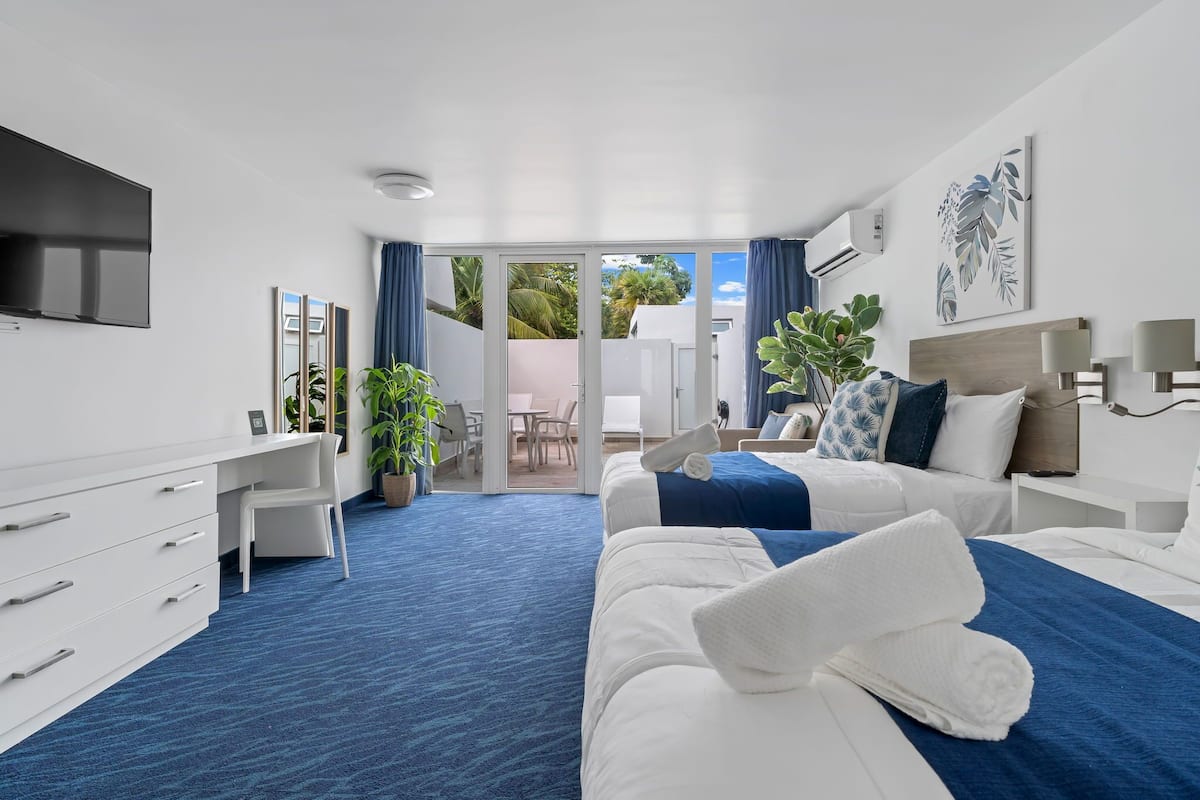 Ein modernes Hotelzimmer mit einem großen Bett, einem Schreibtisch und einem Fernseher.