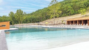 Une piscine avec des chaises longues et un bâtiment en bois.