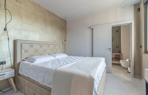 Ein Schlafzimmer mit einem großen Bett, einem Nachttisch und einem Kleiderschrank.