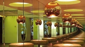 A modern interior with circular seating and reflective surfaces.