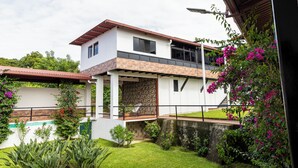 A modern two-story house with a balcony, a swimming pool, and lush greenery. - Summit 503 Rental Villas (Santa Tecla)