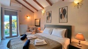 Habitación de hotel con una cama grande, dos lámparas de noche, una silla, un radiador y obras de arte en las paredes.