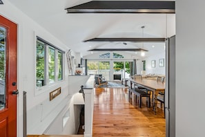 A spacious kitchen with a long wooden countertop, large windows, and a view of the outdoors. - Lakefront Cottage w/ Hot Tub & Dock on Lake Rescue (Ludlow)