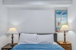 A hotel room with a bed, two nightstands, two lamps, and a painting on the wall. - Lakefront Cottage w/ Hot Tub & Dock on Lake Rescue (Ludlow)