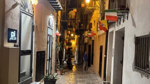 A narrow alleyway with stone paving, balconies with railings, and potted plants. - Cristofaro home 2 (Palermo)