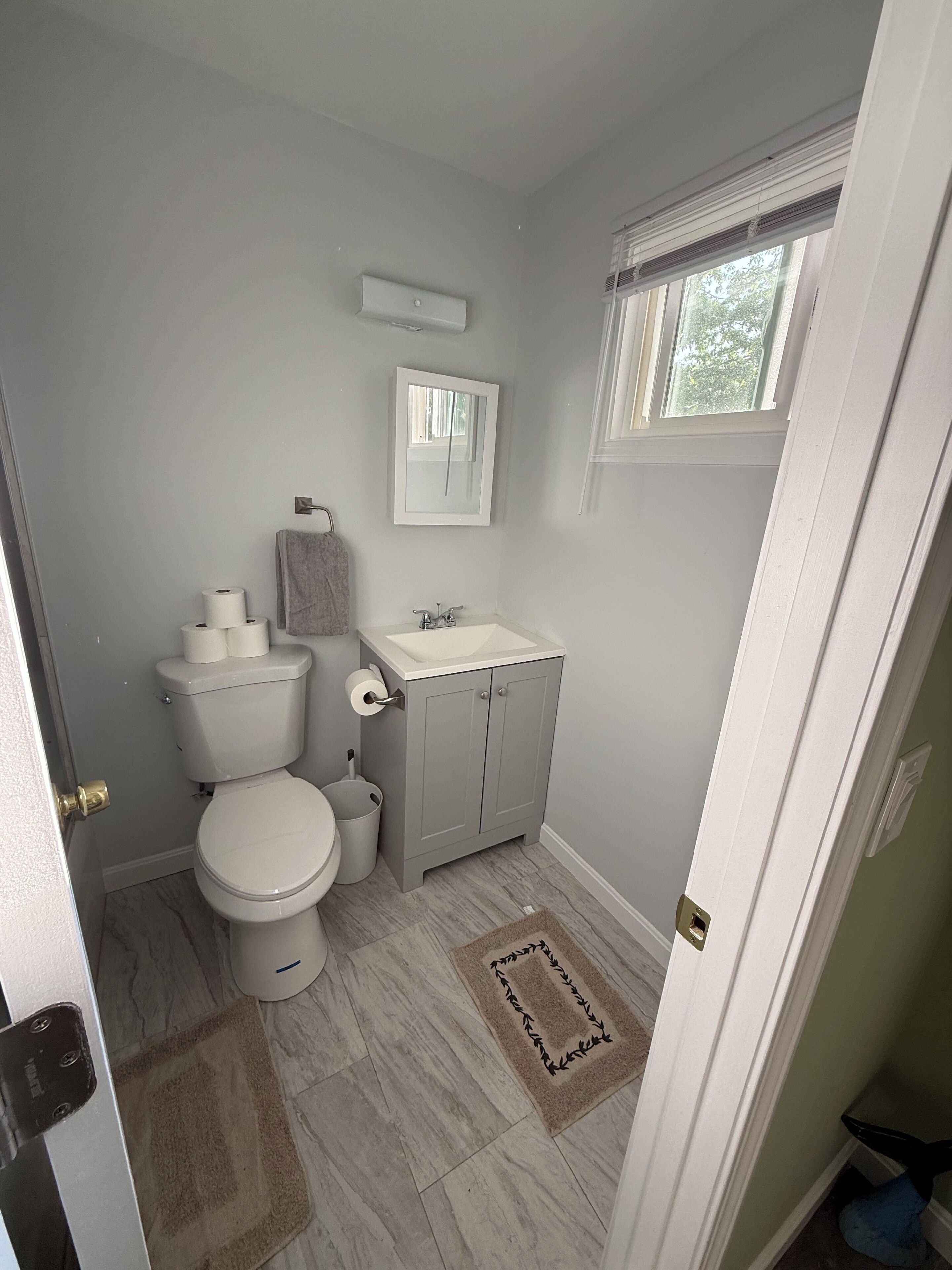 Een badkamer met toilet, wastafel en raam.