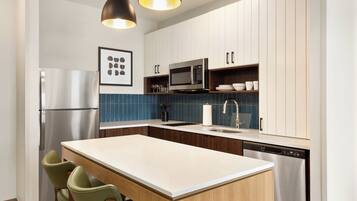 Una cocina moderna con una isla central, electrodomésticos de acero inoxidable y armarios de madera.