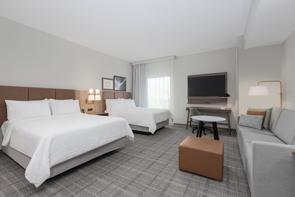 A hotel room with two beds, a desk, a TV, and a sofa. - Staybridge Suites Indianapolis South - Greenwood by IHG (Greenwood)