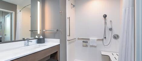 Ein modernes Badezimmer mit einem Doppelwaschbecken, einer bodengrossen Dusche und einem grossen Spiegel.