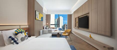 A modern hotel room with a large bed, a desk, a chair, and a TV.