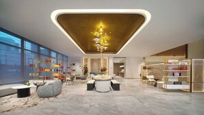 A modern lobby with a central round table, seating arrangements, and a decorative chandelier. - voco Chengdu Chunxi Road by IHG (Chengdu)