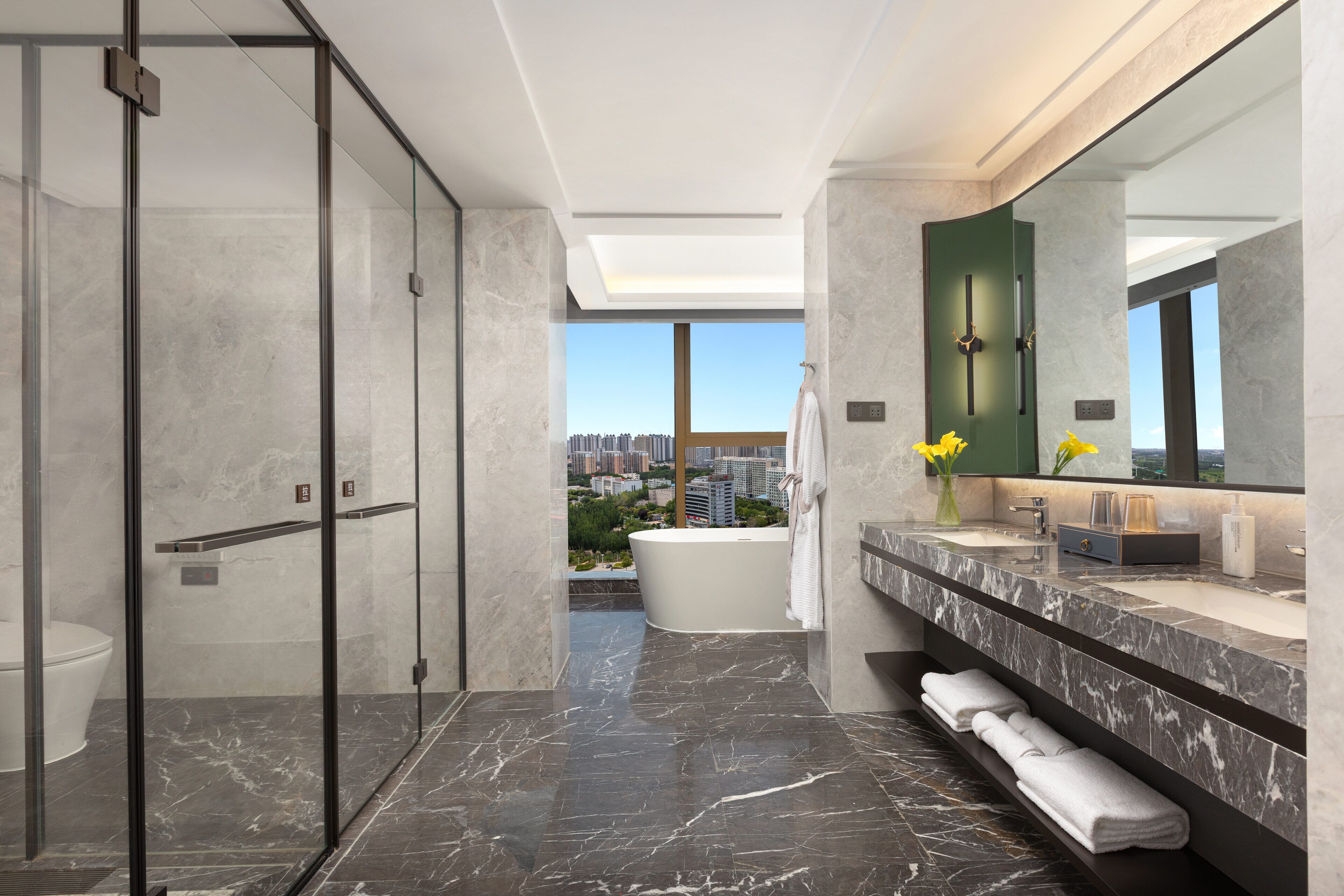 Een moderne badkamer met een douchecabine van glas, een vrijstaand bad en een wastafel met een grote spiegel.