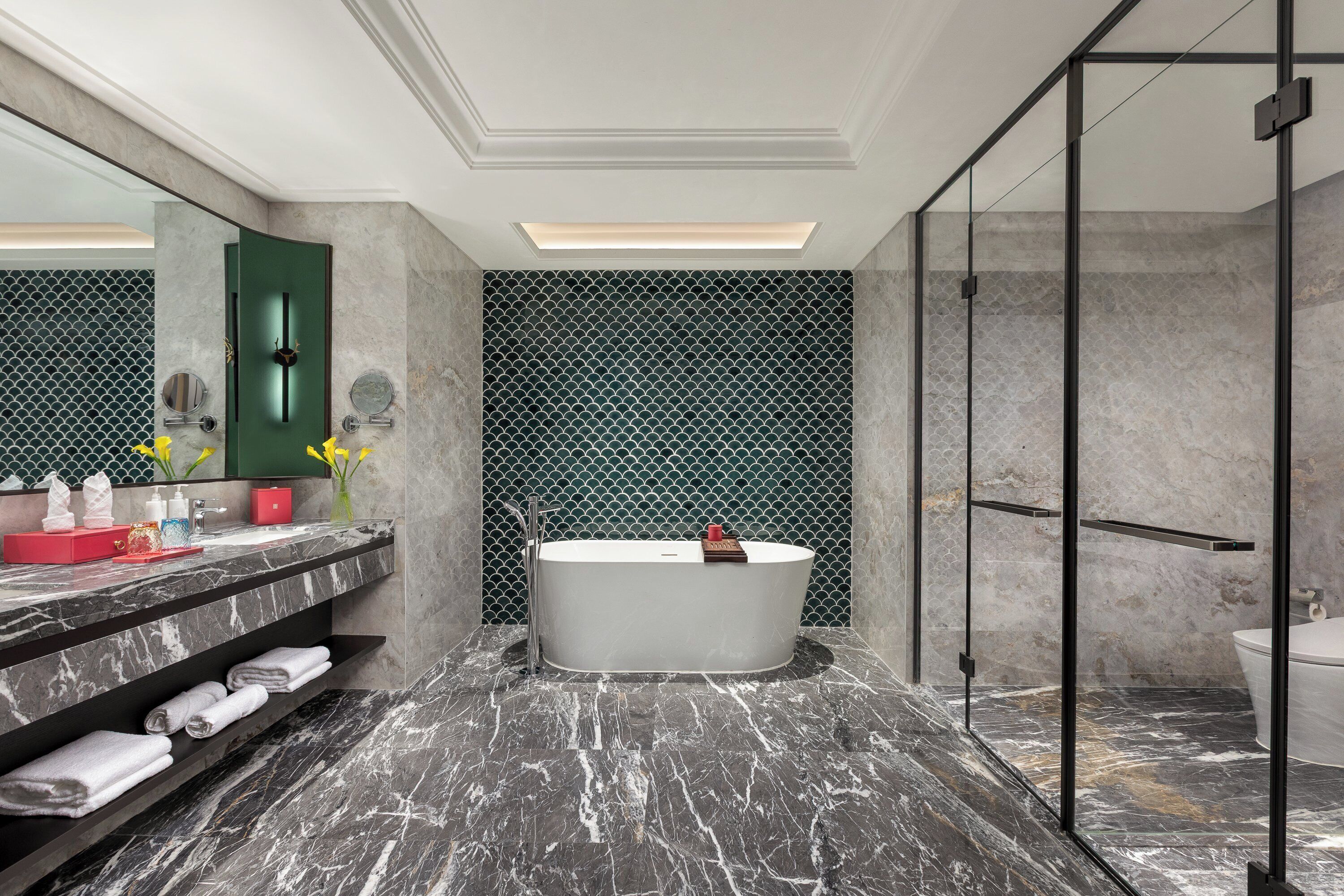 Un bagno moderno con una vasca autonoma, pavimento in marmo e cabina doccia in vetro.