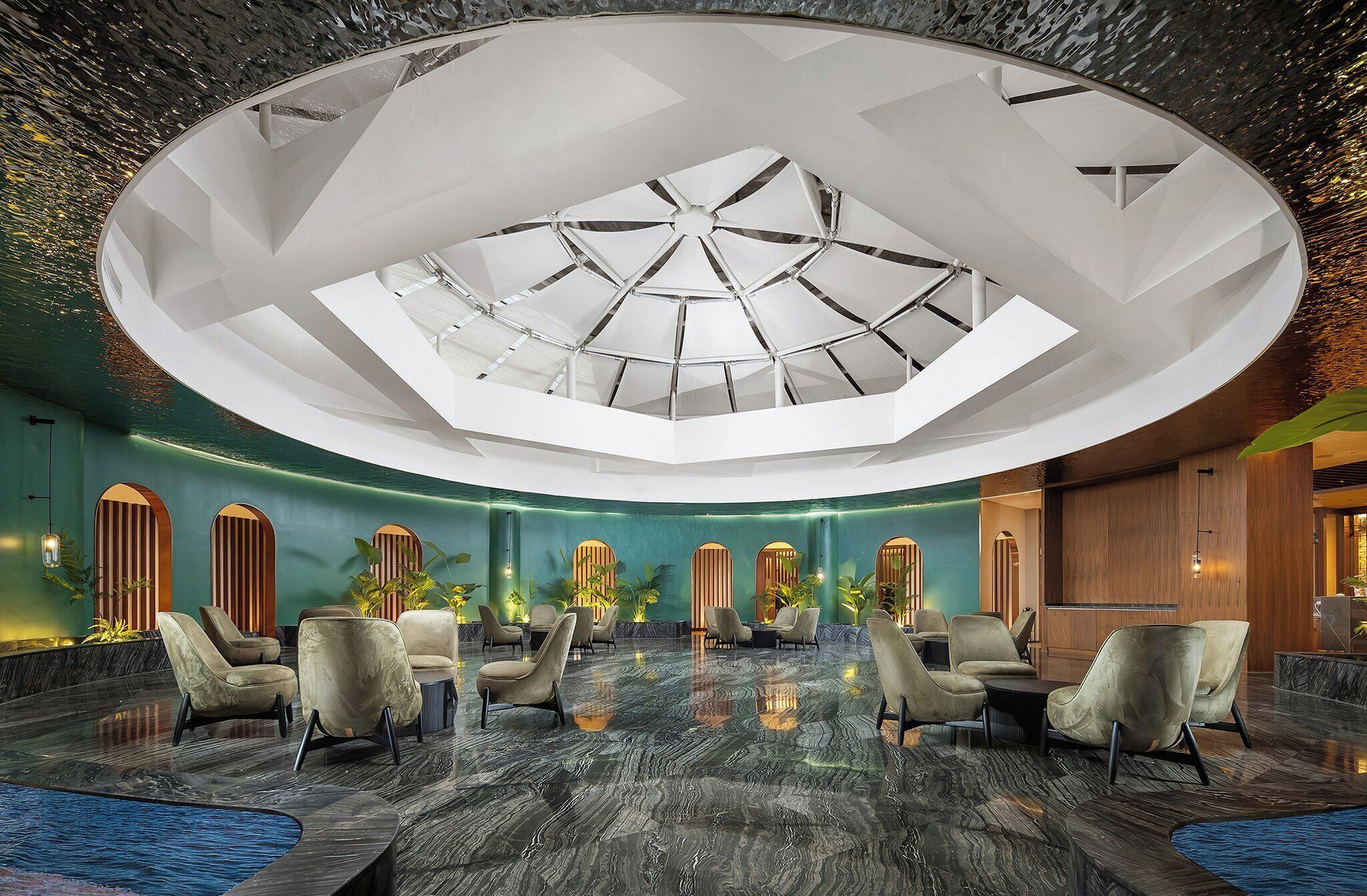 A spacious lobby with a high ceiling, a central skylight, and a seating area with modern chairs.
