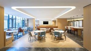 Un comedor moderno con una disposición central de asientos, ventanas amplias y un diseño de techo contemporáneo.