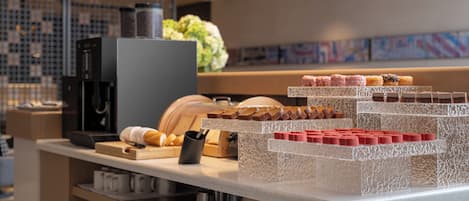 Une vitrine de boulangerie présentant diverses pâtisseries et une machine à café.