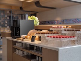 A bakery display with various pastries and a coffee machine.