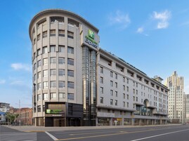 A Holiday Inn Express hotel with a curved corner design, multiple floors, and a modern facade.
