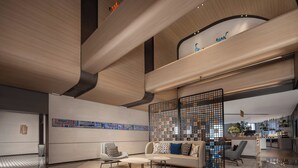 Ein modernes Interieur mit einer Couch, Sesseln und einer Küchenzeile.
