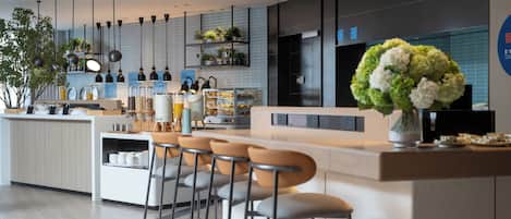 A modern bar area with a counter, bar stools, and a decorative vase.