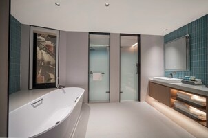 Un baño moderno con una bañera independiente, una ducha con cerramiento de vidrio y un lavamanos con espejo.