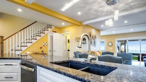 A kitchen with a granite countertop, stainless steel appliances, and a built-in dishwasher. - Peaceful Point Lakehouse with Hot tub (Leamington)