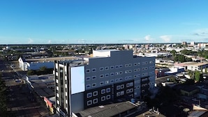 Un edificio de varios pisos con techo plano, varias ventanas y un estacionamiento al frente.