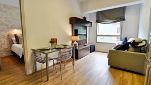 Un espacio habitable compacto con comedor, kitchenette y sofá.