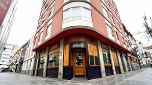 Un edificio en esquina con fachada de madera y un cartel que dice 'Nabisco Club'.