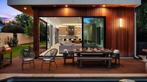 A modern outdoor living area with a pool, deck, and dining setup. - Casa Sol - Heated Pool, Outdoor Living & Design (Austin)
