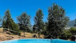 A clear blue pool surrounded by trees and a white poolside area. - Camping near Sequoia Kings Canyon National Park #8 (Yokuts Valley)