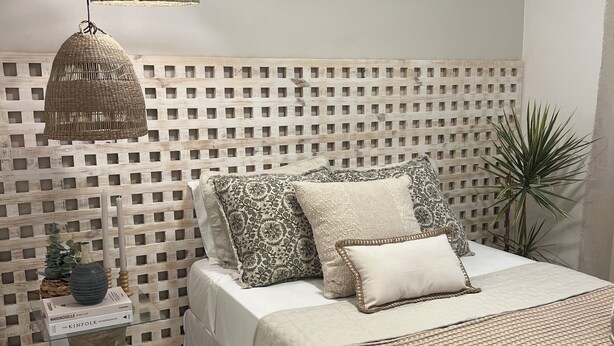 A bedroom with a bed, bedside table, decorative pillows, a woven headboard, and a potted plant. - Pousada Estrela do Norte (Tibau do Sul)